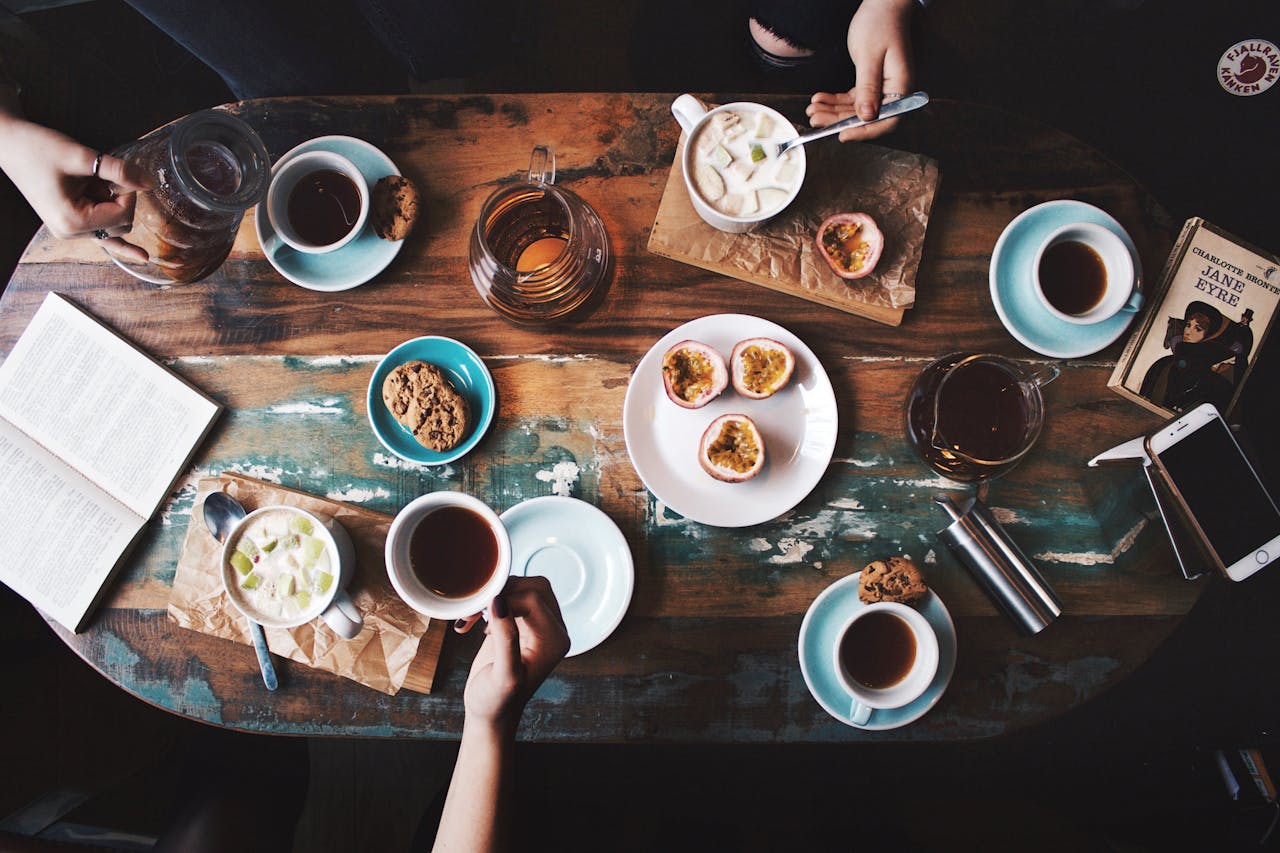 who-we-are Overhead view of a cozy coffee table setup with cups, snacks, and books, perfect for a relaxing afternoon.